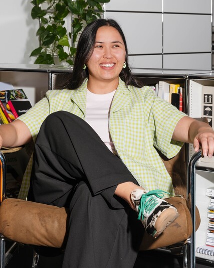 Desirée Lanz sits smiling in a leather armchair in front of bookshelves.