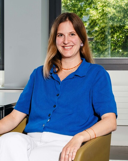 Livia Sager sits smiling in an armchair by the window.