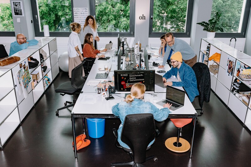 Several team members work together in an open-plan office.