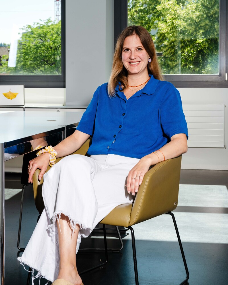 Livia Sager sits smiling in an armchair by the window.