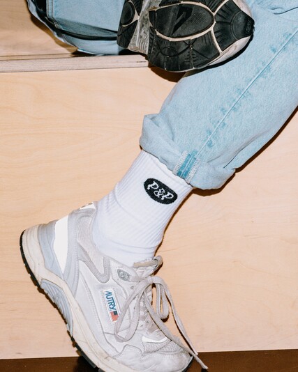 Jasmina Seelig sits with her legs crossed, with her trainers shown in close-up.
