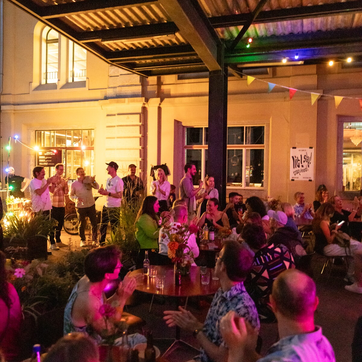Guests celebrate under coloured lights in a covered courtyard.